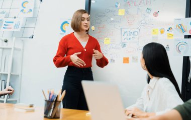 Profesyonel çekici kadın lider, modern iş toplantı odasında beyin fırtınası zihin haritalama istatistikleri ve renkli yapışkan notlar kullanarak yaratıcı pazarlama planını sunuyor. Tertemiz..