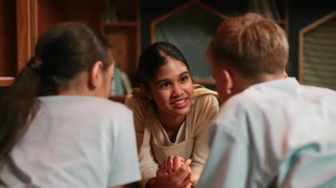 Kafkasyalı bir kız kütüphanede çok kültürlü bir arkadaşıyla kitap okurken aynı deneyimi paylaşıyor. Bir grup mutlu öğrenci kitaptan İngilizce öğrenirken ya da okurken konuşuyor. Öğretim