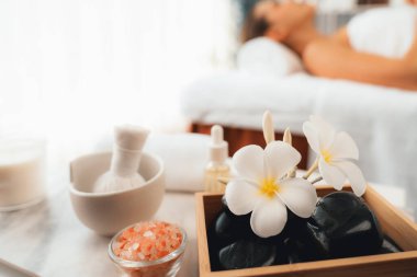 Aromaterapi masajı gündüz atmosferinde ya da spa salonunda bulanık bir kadına odak dekor ve spa aksesuarları kurarak tatil köyünde ya da otel arka planında keyifli aroma spa masajı yapan bir masaj. Sessiz.