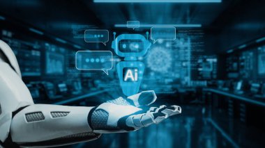 Bu resim, dijital iletişim elemanlarının bulunduğu gelecekteki bir laboratuvarda ileri teknolojiyi temsil eden parıldayan bir üç boyutlu yapay zeka simgesini gösteren bir robot eli gösteriyor. Auvana