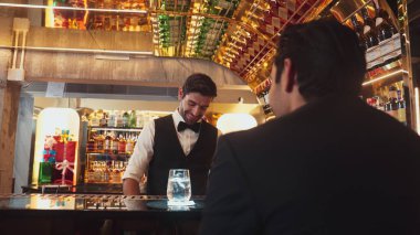 Akıllı barmen, lüks bir tezgahta arkadaşını beklerken limonlu cin kokteyli ikram ediyor. Barmen, canlı gece hayatı parti atmosferinde mükemmel hizmet veriyor. Vinosity.