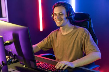 Kazanmak için çevrimiçi oyun oynayan akıllı flama makinesinin sunucu kanalı, neon ışıklı odada seçilen takım yarışması için izleyicilerle birlikte canlı yayında canlı yayında kulaklık takıyor. Bireysel.