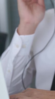 Kulaklık takan bir iş adamı ofiste çalışıyor. Arama merkezi, tele pazarlama, müşteri destek acentesi telefon görüşmesinde hizmet sunar.