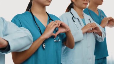 Profesyonel sağlık personeli kuyrukta bekleyip, birlikte el kaldırarak sağlık hizmetleri ve hastanedeki doktor liderliğini sembolize ediyorlar. Takım çalışması başarılı tedaviye yol açar. Düşük hareket. Katı.