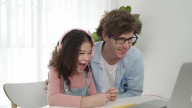 Amerikalı kız, kod yazmayı ve mühendislik yazmayı öğrenirken olumlu baba da birlikte çalışıyor ve programlama kodunu veya sistemini özenle göstermek için dizüstü bilgisayarına işaret ediyor. Pedagoji.