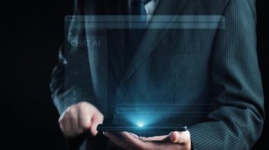Takım elbiseli bir profesyonel, modern iletişim teknolojisini vurgulayarak yapay zeka sohbet baloncuklarıyla dijital sohbet arayüzü sergileyen bir akıllı telefon sunuyor. Dörtgen