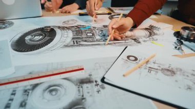 Yaratıcılık ve yeniliğin altını çizerek, modern çalışma alanındaki detaylı teknik çizimler ve prototip bileşenleriyle tasarım sürecinde yer alan canlı bir sahne gösterici eller. SACTR