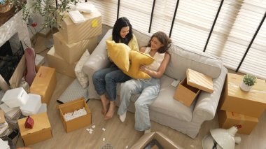 Lezbiyen aşığın taşınma gününde oturma odasında kanepede otururken yastık savaşı yapması. Oda arkadaşı odada yastık tutarken birlikte vakit geçirir. Kutu etrafa saçılmış halde. Myrmidon.