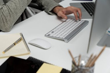 Gündelik işlerde çalışan kıyılmış işadamı, modern ofisteki bilgisayar ekranında borsa borsa veritabanını analiz ederek sunum için iş pazarlama raporunu araştırmak için bilgisayarı kullanıyor. Bireysel.