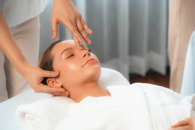 Kafkasyalı kadın stres önleyici kafa masajından ve lüks tatil beldesi ya da otel spa salonundaki modern ışık ortamında yüz güzelliği eğlencelerini şımartmaktan hoşlanıyor. Sessiz.