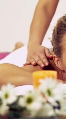 Rahat bir kadın profesyonel masaj terapistiyle lüks kaplıcalarda masaj yaptırıyor. Sağlık, şifa ve rahatlama konsepti.