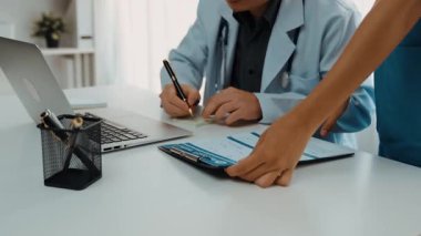 Hastane masasında birlikte çalışan ve tıbbi tedavi planlayan çeşitli profesyonel sağlık görevlileri. Takım çalışması başarılı hastalıklara ve hastalıklara yol açar. Ağır çekim. Katı.