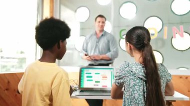 Kameraya bakmak için arkanızı dönerken çeşitli öğrenci programlama sistemleri. BTMM Teknoloji sınıfında çok kültürlü bir öğrenciye kodlama dersi veren beyaz bir öğretmen. Öğretim