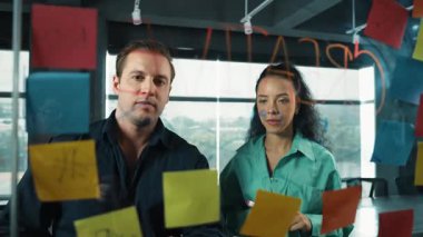 Yetenekli işadamı pazarlama fikrini cam duvardaki proje yöneticisine sundu. Yönetici projeyi yatırımcıya açıklıyor. Zeki iş adamları birlikte çalışıyor, beyin fırtınası yapıyorlar. Yönlendirici.