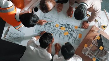 Becerikli mühendis ekibinin ev inşaatından bahsedişinin en alt görüntüsü. Mimar ya da tasarımcı grubunun planlar hakkında beyin fırtınası yapmak için tartışan ve yazan hava görüşü. Hizalama.