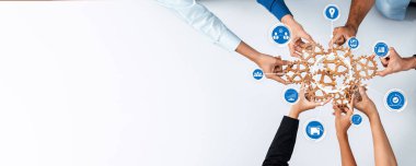 Çeşitli bireylerden gelen eller, fikirleri, takım çalışmasını ve proje yönetimi kavramlarını temsil eden yenilikçi sembollerle temiz beyaz bir yüzey üzerinde işbirliğine katılıyorlar. Dostluk