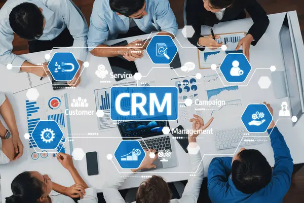 Çeşitli iş adamları modern ofis ortamında veri odaklı görseller ve grafiklerle işbirliği içinde CRM strateji tartışmasına giriştiler. Takım çalışmasına ve üretkenliğe odaklan. Dostluk
