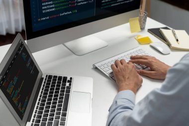 Bilgisayarda bilgisayar ve bilgisayar üzerinde çalışan ve uygulama projesinde kodlama programı olan bilgisayar geliştiricisinin kırpılmış görüntüsü. Teknik mühendis önemli not listeleri yazıyor. Bireysel.