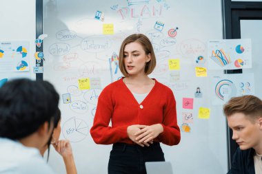 Profesyonel çekici kadın lider, modern iş toplantı odasında beyin fırtınası zihin haritalama istatistikleri ve renkli yapışkan notlar kullanarak yaratıcı pazarlama planını sunuyor. Tertemiz..