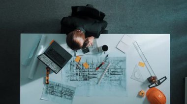 İş kadınının proje planı, ekipman ve güvenlik kaskıyla toplantı masasında oturan mühendis el planının en üst görüntüsü. Yöneticinin hava görüntüsü bina inşaatını açıklıyor. Hizalama.