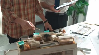 Akıllı mimar ya da inşaat mühendisi bina yapısı fikrini not edip plana yapıştırıyor. Yöneticinin çeşitli meslektaşları ve ev planlarıyla birlikte çalıştığı hava görüşü. Hizalama.