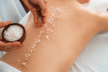 Lüks spa salonunda sıcak mum ışığı atmosferi olan kaplıca tedavisi gören kadın müşteri. Sağlık kaplıcasında güzellik tedavisiyle tuz temizliği. Sessiz.