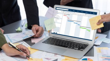 Analizci ekibi yaratıcı ve analitik beyin fırtınası fikri için bilgisayar ekranında BI veri paneli olan yapışkan bir not kullanıyor. Pazarlama stratejisi için finansal veri görselleştirme teknolojisini analiz et. Dahi.