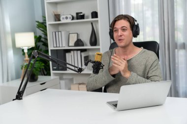 Sunucu kanalı, gülümseyen akıllı yayıncı kaydı, senaryosu ve akıllı telefonuyla sosyal medyada sohbet programı, kulaklık takarak modern ev stüdyosundaki video flamalarını kaydediyor. Bireysel.