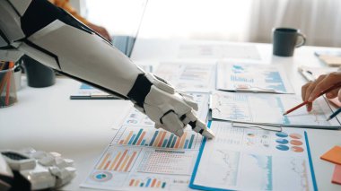 Robotik bir kol modern ofis ortamında veri analizini kolaylaştırır, detaylı raporlar ve chartlar yoluyla teknoloji ve iş süreçlerinin kesişmesini temsil eder.