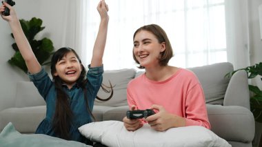 Mutlu çocuk oyun oynuyor ve oturma odasında otururken annesini kazanıyor. Çekici kız elini havaya kaldırıp şarapları kutlarken beyaz bir anneyle vakit geçiriyor. Pedagoji.