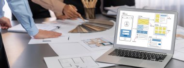 İç mimar tasarımcı grubu, daha kesin tasarım için planlar ve dizüstü bilgisayar ekran mimari yazılımı üzerinde birlikte tartışıyorlar. Modern ev tasarımı ve yenileme. İçgörü