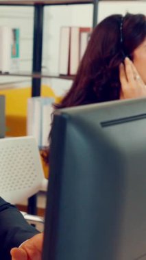 Ofiste çalışan kulaklık takan işadamları uzak müşteri ya da meslektaşlarını desteklemek için çalışıyorlar. Arama merkezi, tele pazarlama, müşteri destek acentesi telefon görüşmesinde hizmet sunar.