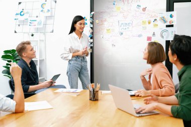 Genç ve güzel lider pazarlama stratejisini sunarken, uzman yatırımcı ve proje yöneticisi de yeni başlayan iş toplantısında iş performansını analiz etmeye çalışıyor. Çok ırklı bir grup. Tertemiz..