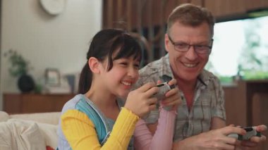 Büyükbaba ve torun birlikte konsol oyunu, eğlence medyası oynuyorlar. Eski kullanım teknolojisi yeni nesil ile iletişim kurar. Nesiller arası uçurum aile bağını güçlendirir. Uyumsuzluk.