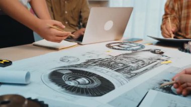 Çeşitli bir ekip, modern bir çalışma alanında karmaşık mühendislik şemaları üzerine ortak bir tartışmaya girişerek yaratıcılığı ve yenilikçi teknolojiyi iş başında gösteriyor. SACTR