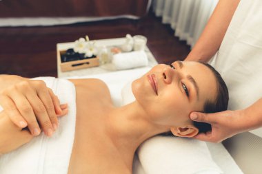 Kafkasyalı kadın stres önleyici kafa masajından ve lüks tatil beldesi ya da otel spa salonundaki modern ışık ortamında yüz güzelliği eğlencelerini şımartmaktan hoşlanıyor. Sessiz.