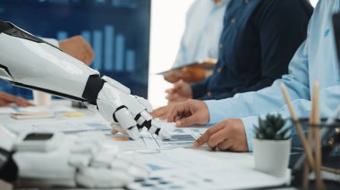 Robot bir kolun insan eliyle etkileşime geçtiği, teknoloji ve kurumsal işbirliğindeki gelişmeleri vurguladığı bir iş toplantısının geleceksel bir sahnesi. Noogenesis