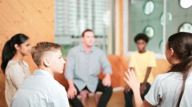 Grup terapisi sırasında soru sormak için elini kaldıran akıllı kız. Lise öğrencisi, grup toplantıları arasında soru sormak, oy vermek, gönüllü olmak, soru sormak ve cevaplamak için el kaldırdı.