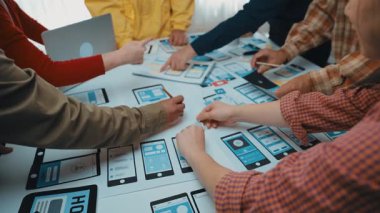 Çeşitli profesyonellerden oluşan dinamik bir grup, yaratıcı süreçlerini geliştirmek için dijital cihazlar ve kağıt prototipler kullanarak parlak bir ofis ortamında yenilikçi fikirler üzerinde işbirliği yapıyor. SACTR