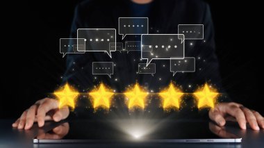 Bir insan dijital arayüzle etkileşime girerek, modern bir bağlamda müşteri memnuniyetini ve çevrimiçi reytingleri sembolize eden beş parlayan yıldız ve geri bildirim baloncuğu sergiliyor. Dörtgen