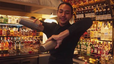 Gülümseyen Asyalı akıllı barmen iki eli karışık kokteylde titreyerek lüks tezgah barında hazırlanıyor, özel içecek hazırlıyor gece hayatı içkisi gece kulübü sıcak. Vinosity.