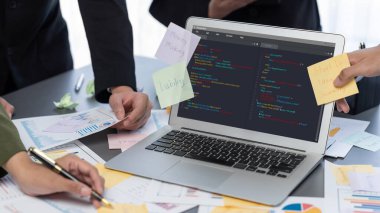 Analizci ekibi yaratıcı ve analitik beyin fırtınası fikri için bilgisayar ekranında BI veri paneli olan yapışkan bir not kullanıyor. Pazarlama stratejisi için finansal veri görselleştirme teknolojisini analiz et. Dahi.