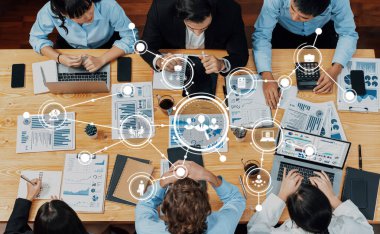 Modern ofis ortamında veri görselleştirmesi, beyin fırtınası ve stratejik planlama yapan profesyonellerle takım çalışması ve teknoloji sergileyen dinamik bir iş toplantısı. Dostluk