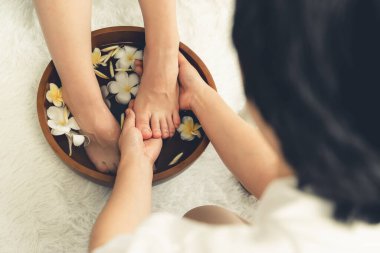 Kadınlar lüks spa salonlarında keyifli ayak masajlarına devam ederken, masör de hafif gün ışığı atmosferinde refleksoloji terapisi veya otel ayak spa 'sında. Sessiz.