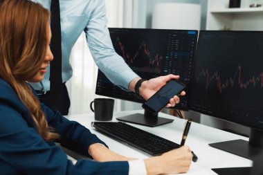 Kâr değeri değeri oranı online web sitesi uygulamasını ev ofisinde analiz etmek için notlar yazan kadınlara telefonda dinamik borsa verilerini gösteren bir işadamı eli kesilmiş. İnfobahn.