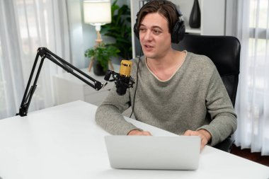 Sunucu kanalı, gülümseyen akıllı yayıncı kaydı, senaryosu ve akıllı telefonuyla sosyal medyada sohbet programı, kulaklık takarak modern ev stüdyosundaki video flamalarını kaydediyor. Bireysel.