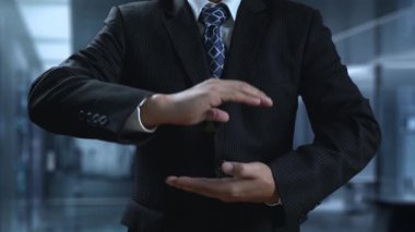 Takım elbiseli bir işadamı büyümeyi ve başarıyı simgeleyen parlak bir ok tutuyor. Arkasında, finansal tablolar ve veri görselleştirmeleri modern bir ofis ortamını vurguluyor. Dörtgen