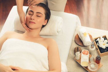 Kafkasyalı kadın stres önleyici kafa masajından ve lüks tatil beldesi ya da otel spa salonundaki modern ışık ortamında yüz güzelliği eğlencelerini şımartmaktan hoşlanıyor. Sessiz.