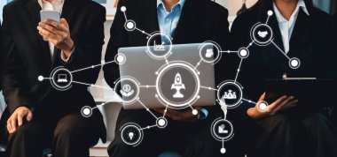 Üç iş adamı, dijital bağlantılar ve takım çalışması yoluyla işbirliği ve yenilikleri gösteren modern bir çalışma alanında teknolojiyle aktif olarak ilgileniyorlar. Dostluk