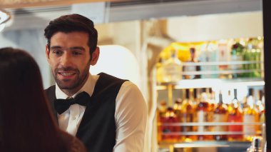 Gülümseyen zeki barmen, gece kulübünde VIP müşterilerle canlı sohbetler yapmak için güzel bir gece partisi atmosferine mükemmel bir servis sunuyor. Vinosity.